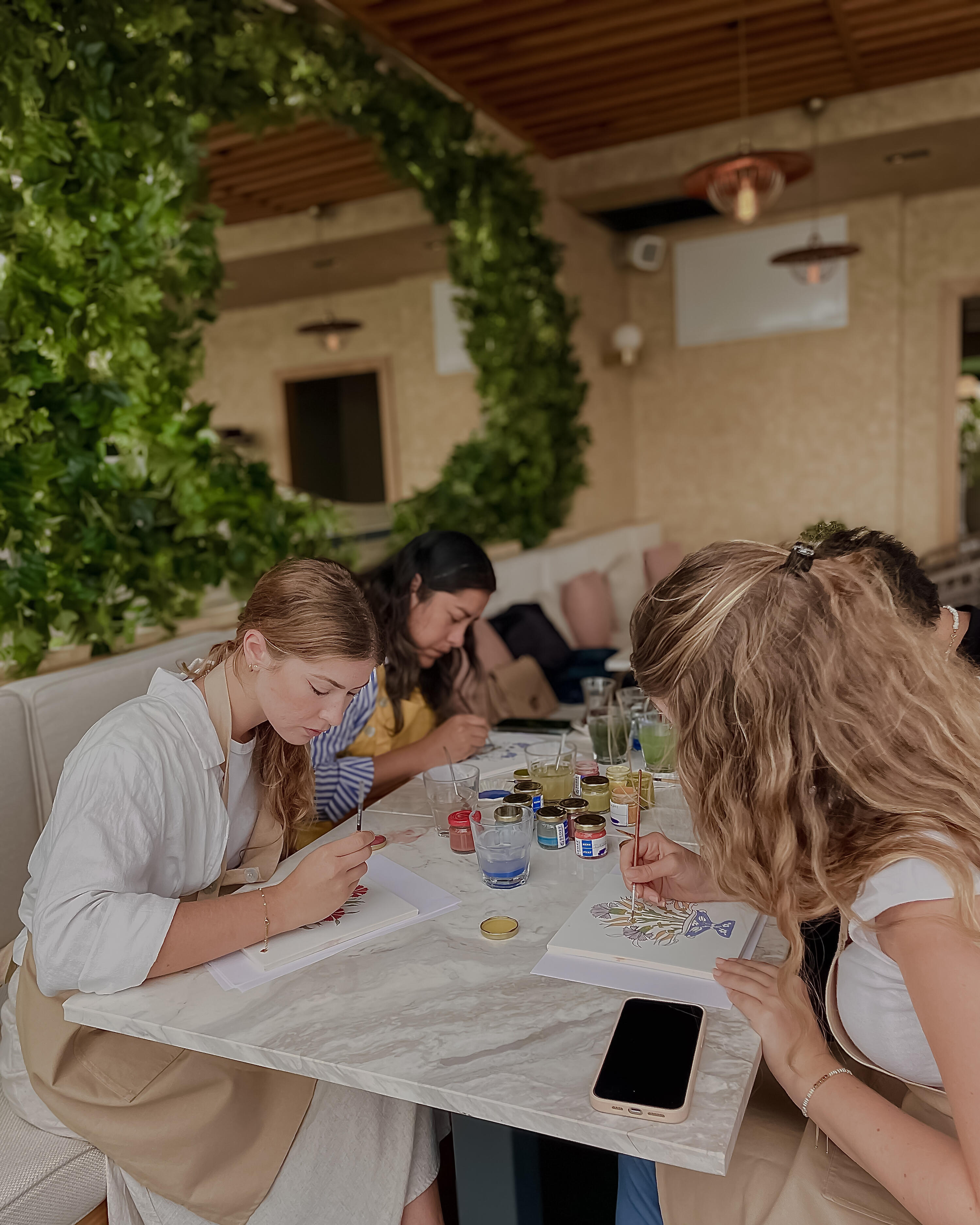 In person Turkish tile painting workshops in Istanbul Women painting ceramic tiles on the table